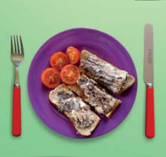 Image of a plate of sardines on toast with a tomato