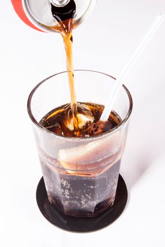 Image of cola can being poured into glass