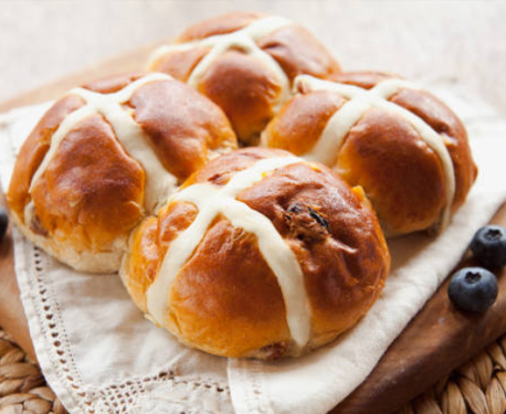 Image of 4 hot cross buns on a board.