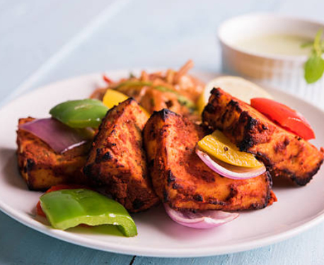 Image of chicken tikka on a plate with vegetables