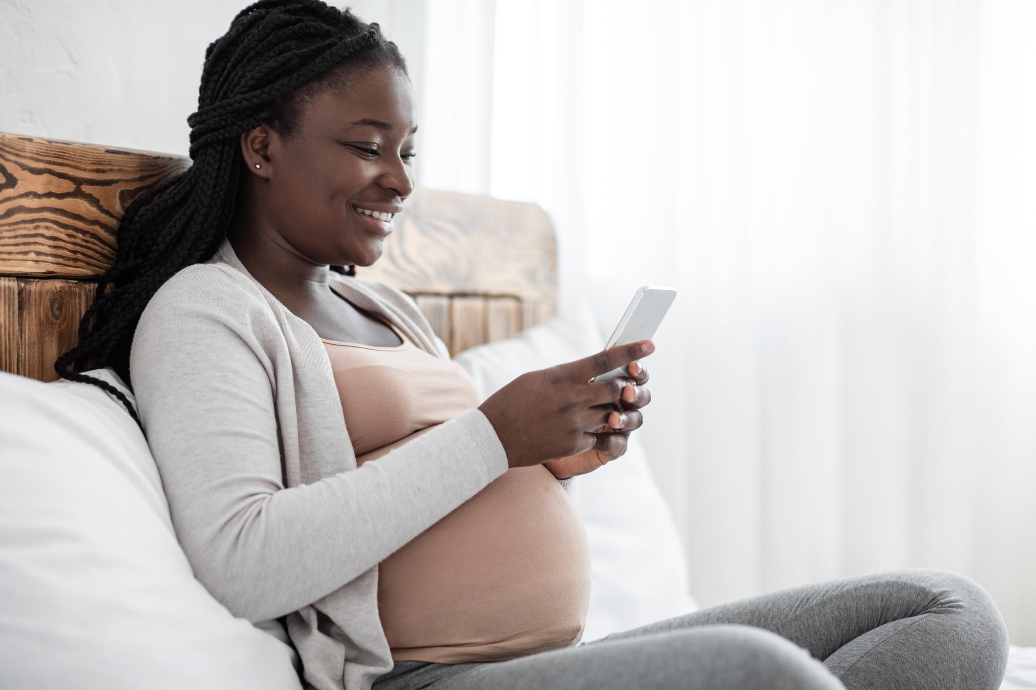 A pregnant woman looking at her phone