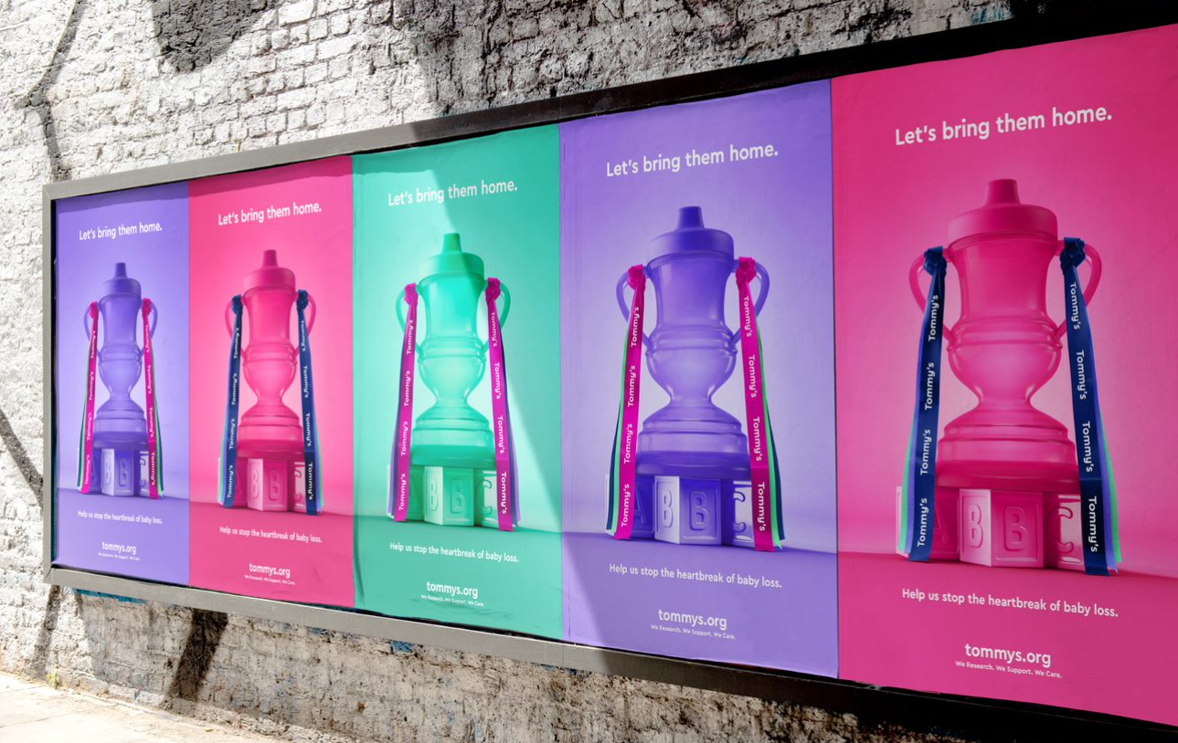 A row of purple, pink and mint green Tommy's ads showing baby tippy cup styled like the FA Cup trophy